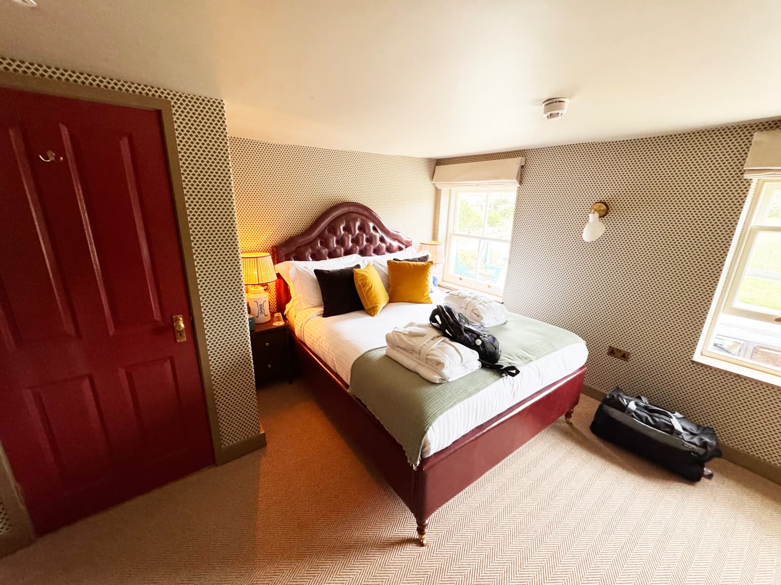 A comfortable bedroom at The Norman Knight with a deep red leather bed